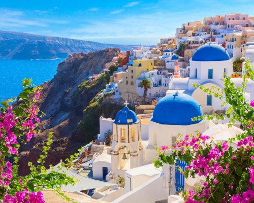 Santorini island, Greece. Oia town traditional white houses and churches with blue domes over the Caldera, Aegean sea.